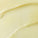The image is a close-up of a smooth, creamy, pale yellow substance, likely a balm or butter. It shows a glossy texture with gentle curves, suggesting it has been spread or swirled. The rich appearance indicates it might be a hydrating skincare product.